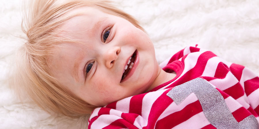 Family photography picture of cute blonde toddler smiling at the camera