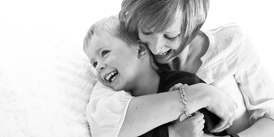 Mum smiles as she bear-hugs her young son