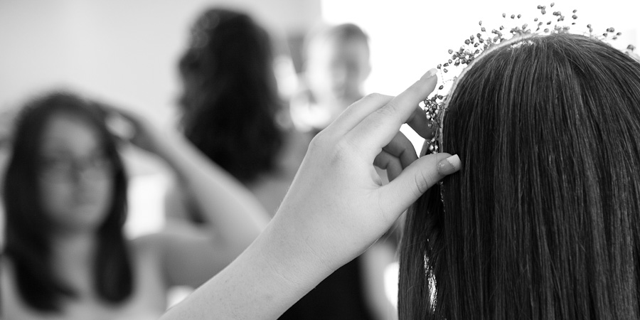 A bride looks into the mirror as she prepares for her wedding in Manchester Town Hall by putting on her tiara