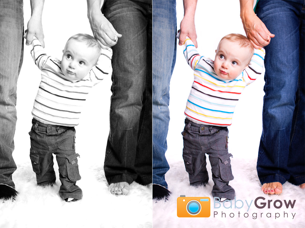 Toddler boy takes his first steps with Mum and Dad