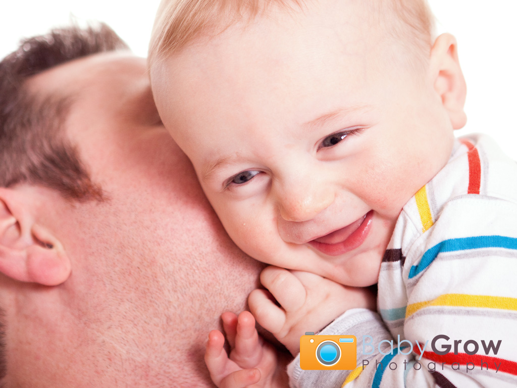 Dad tickling his smiling toddler son