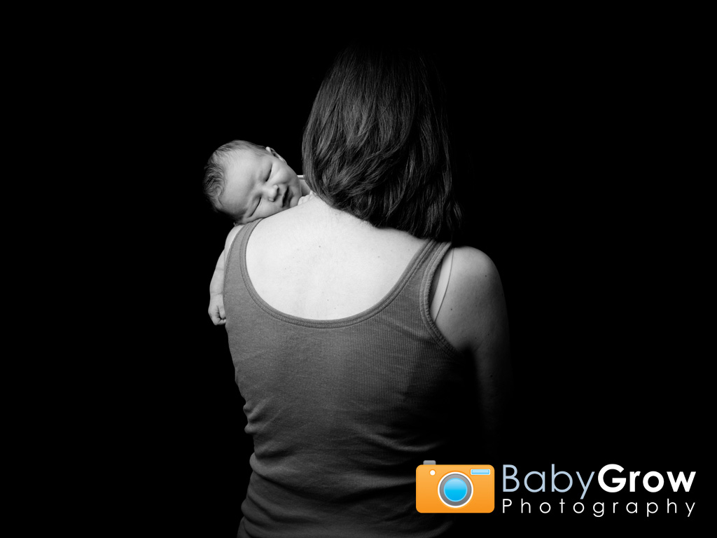 Mum hugs her sleeping newborn baby