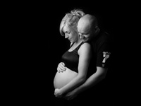 Expectant Mum and Dad looking down at baby bump