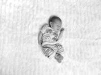 Newborn baby boy asleep in the middle of a blanket
